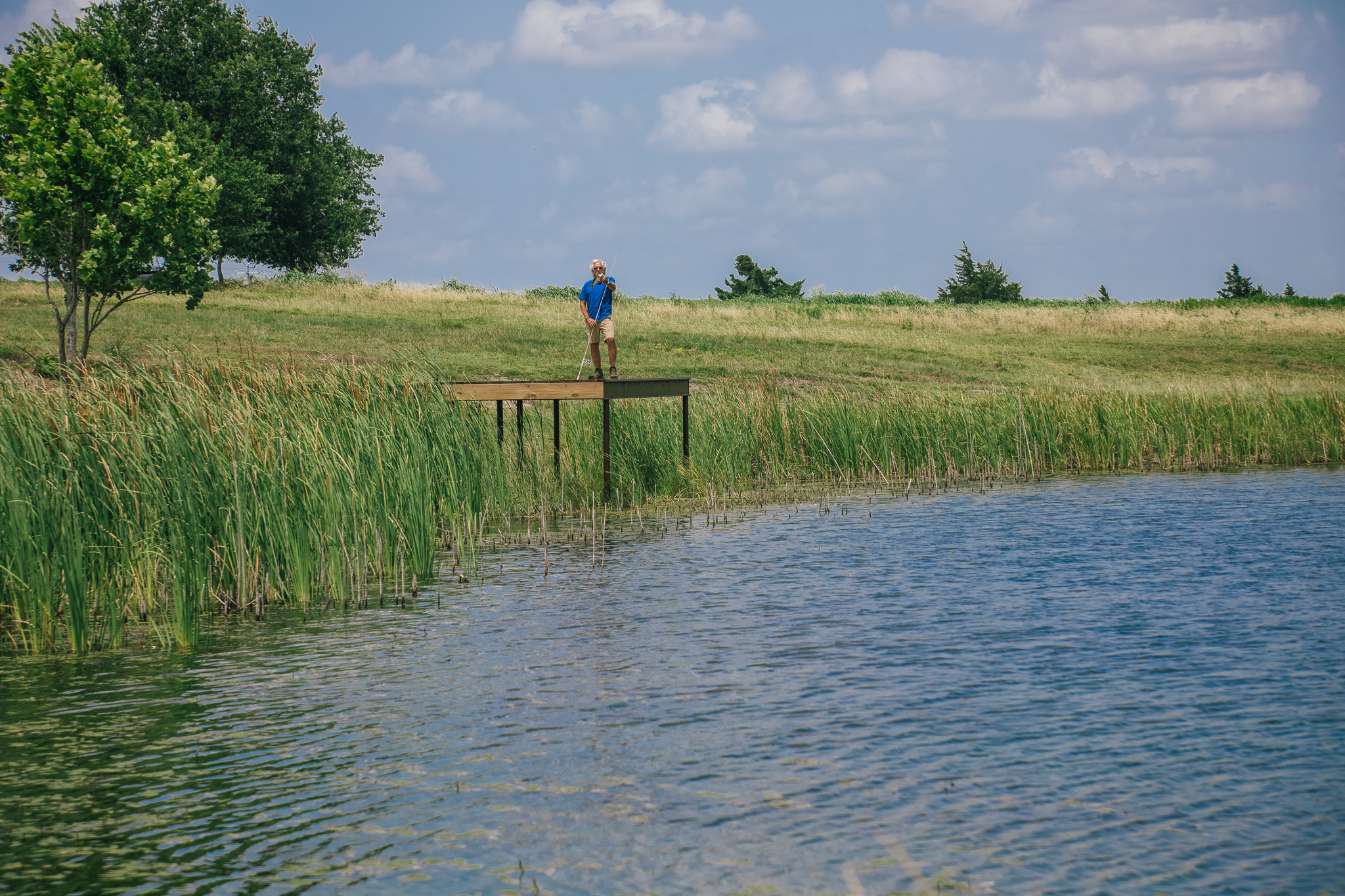 Holding a largemouth bass on the dock — Lot 3, The Clearing