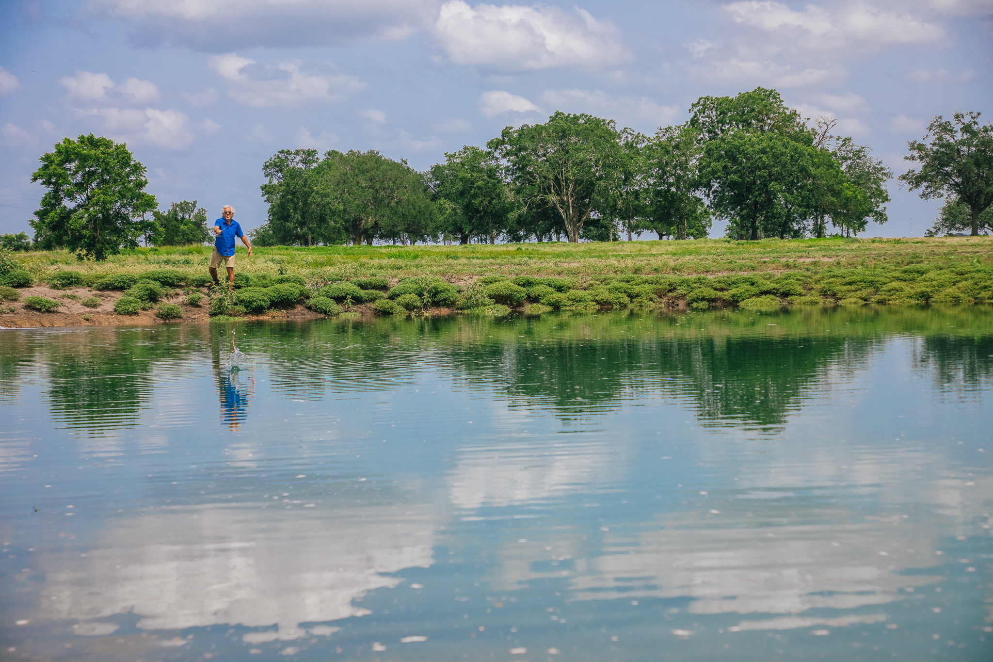 Man casting into pond, clean reflection — Lot 1