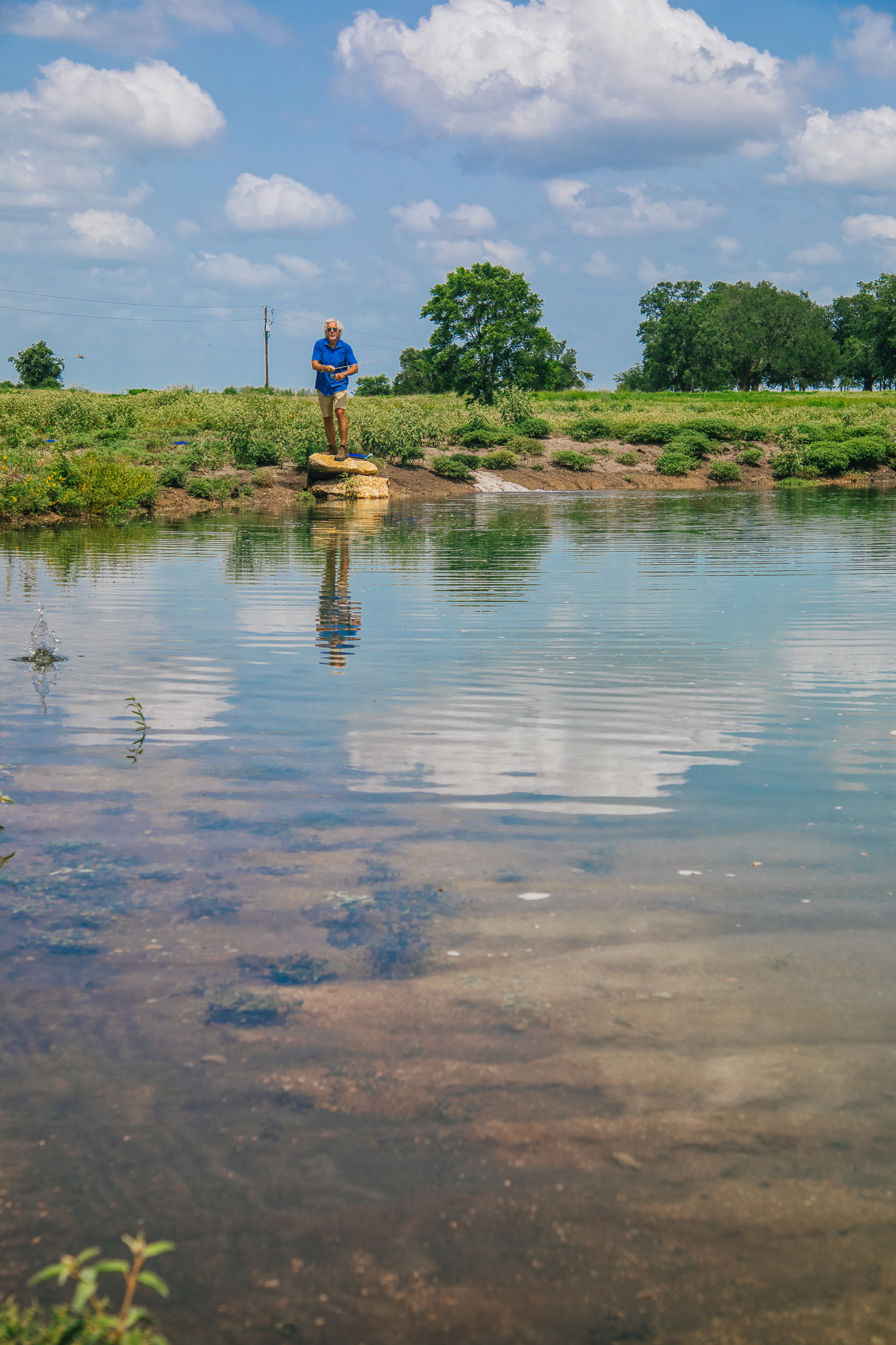 Man fishing on rock, wide pastoral view — Lot 1 pond
