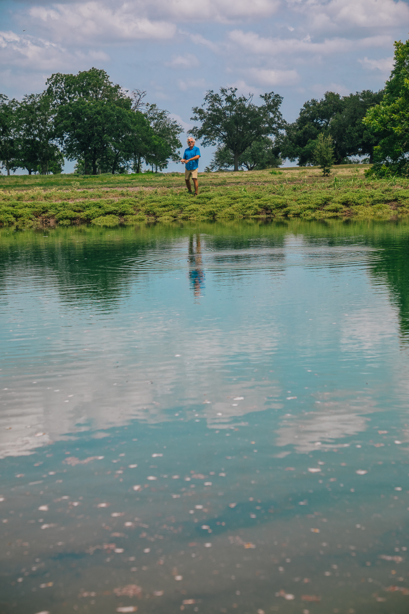 Man fishing on bank with splash, new pond — Lot 1